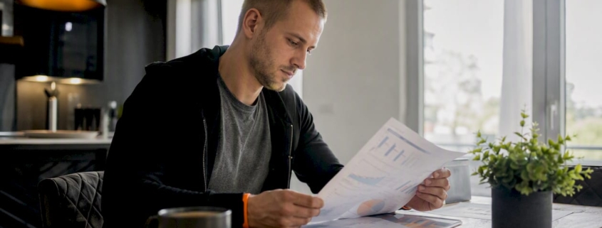 Ein Marketingexperte prüft die Ergebnisse seiner Google Ads-Kampagne anhand ausgedruckter Berichte.