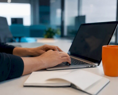 Hände richten auf einer dunklen Laptop-Tastatur die Einstellungen für ein Tracking-Tool ein.