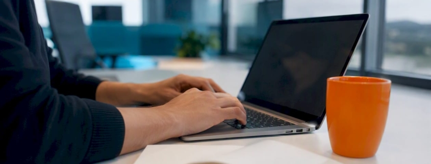 Hände richten auf einer dunklen Laptop-Tastatur die Einstellungen für ein Tracking-Tool ein.