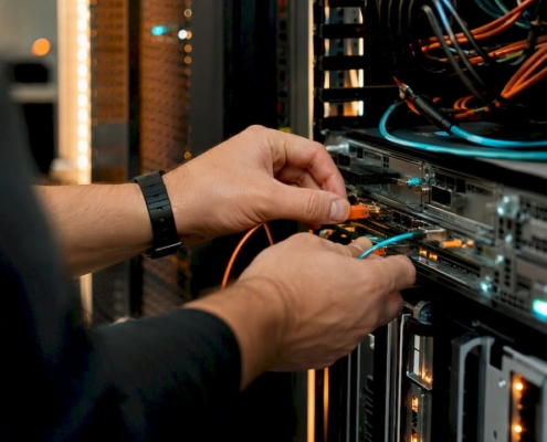 Ein Techniker schließt im Serverschrank ein Netzwerkkabel an.