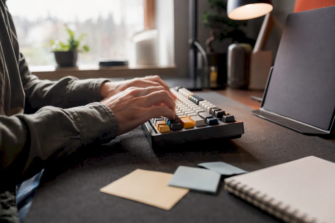 Hände, die auf einer bunten Tastatur Daten eingeben